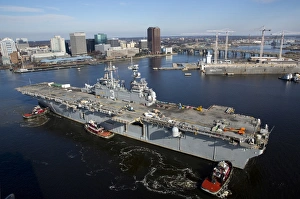 Tugboats position the amphibious assault ship USS Kearsarge Tugboats position the amphibious assault ship USS Kearsarge
