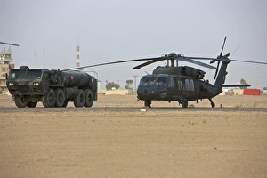 A UH-60 Black Hawk helicopter and its refueler truck A UH-60 Black Hawk helicopter and its refueler truck