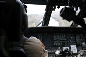 A UH-60 Blackhawk flies the river to an unknown village to drop off a care package A UH-60 Blackhawk flies the river to an unknown village to drop off a care package