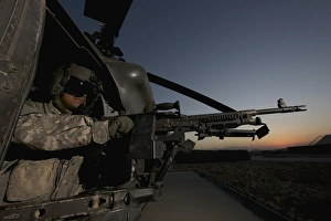 A UH-60L Blackhawk door gunner mans a M-240G machine gun A UH-60L Blackhawk door gunner mans a M-240G machine gun