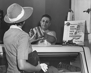A woman donates her cooking fat to a butcher. circa June 1942 A woman donates her cooking fat to a butcher. circa June 1942