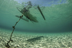 A wooden outrigger anchored near a remote island in Indonesia A wooden outrigger anchored near a remote island in Indonesia