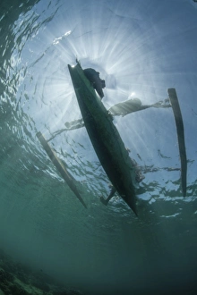 A wooden outrigger near a remote island in Indonesia A wooden outrigger near a remote island in Indonesia