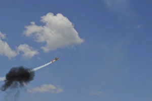 A Yakovlev Yak-55M aerobatic aircraft flys through a smoke ring A Yakovlev Yak-55M aerobatic aircraft flys through a smoke ring