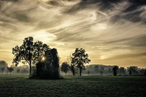 Images Dated 24th November 2014: Old abandoned house covered by vegetation at sunset