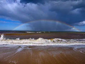 Autumn high tides with stormy skies and rainbow over the sea, Walcott, Norfolk, England Autumn high tides with stormy skies and rainbow over the sea, Walcott, Norfolk, England