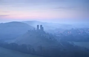 Images Dated 24th April 2010: Corfe Castle, sunrise and early morning mist, view from West Hill, Corfe, Dorset, England, UK