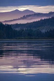 Forested scenery, with hills, mist and protected waters Forested scenery, with hills, mist and protected waters