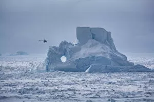 Helicopter from Russian icebreaker Kapitan Khlebnikov flies past iceberg in the Weddell