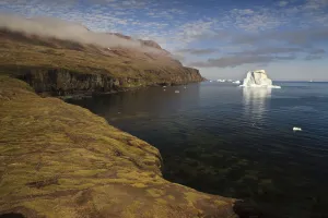Icebergs just off the coast with low clouds over the cliffs, Qeqertarsuaq, Disko Bay Icebergs just off the coast with low clouds over the cliffs, Qeqertarsuaq, Disko Bay
