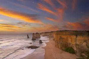 The moon over the eroded coastline of the Twelve Apostles at dusk The moon over the eroded coastline of the Twelve Apostles at dusk