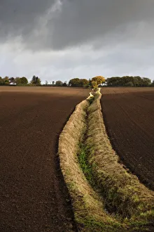 An open field ditch through farmland of recently ploughed fields, Wirral, Cheshire, UK. October, 2020 An open field ditch through farmland of recently ploughed fields, Wirral, Cheshire, UK. October, 2020