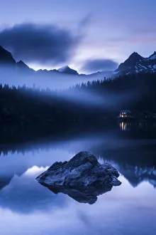 Popradske Pleso, looking toward mountain range, in late evening light, with reflections and mist Popradske Pleso, looking toward mountain range, in late evening light, with reflections and mist