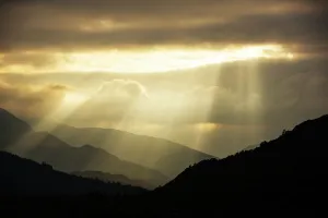 Shafts of light at dusk over Wrynose pass and the Coniston hills from Ambleside, Lake District Shafts of light at dusk over Wrynose pass and the Coniston hills from Ambleside, Lake District