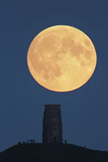Super moon rising above Glastonbury Tor with people watching, Somerset, England, UK Super moon rising above Glastonbury Tor with people watching, Somerset, England, UK