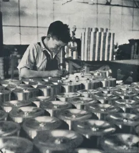 Air Transport Industry Prints: Apprentice with microscope (testing the hardness of pistons), 1941. Artist: Cecil Beaton