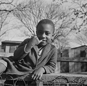 Boy playing on a fence, Washington (southwest section), D.C. 1942. Creator: Gordon Parks