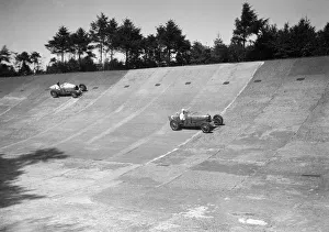 Two Bugatti Type 35s racing on the Members Banking at Brooklands. Artist: Bill Brunell Two Bugatti Type 35s racing on the Members Banking at Brooklands. Artist: Bill Brunell