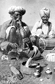 Charming the venom from a cobra; a snake charmer with a mongoose, India, 1922 Charming the venom from a cobra; a snake charmer with a mongoose, India, 1922