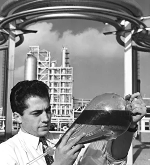 A laboratory worker holds a separating funnel of oil, Dunkirk refinery, France, 1950s A laboratory worker holds a separating funnel of oil, Dunkirk refinery, France, 1950s