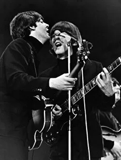 Singers Gallery: Paul McCartney and George Harrison share a microphone on stage