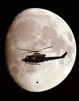 Images Dated 18th August 2005: A Griffin Helicopter, with an underslung load, shown in silhouette against a full moon