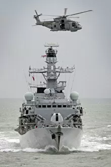 Royal Navy Type 23 Frigate HMS Sutherland with a Merlin Helicopter Overhead