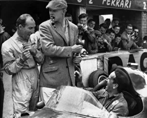 Images Dated 12th July 2010: 1958 British Grand Prix: Stirling Moss, retired, shares a joke with Mike Hawthorn, 7th position