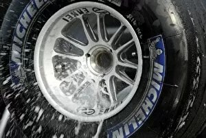 Formula One Testing: A McLaren mechanic washes the used Michelins