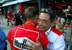 Images Dated 10th March 2004: Formula One World Championship: Pole position winner Michael Schumacher Ferrari is embraced by