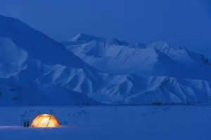 A Backpacking Tent Lit Up At Twilight Alaska Range In The Distance In Winter Isabel Pass Richardson Highway Interior A Backpacking Tent Lit Up At Twilight Alaska Range In The Distance In Winter Isabel Pass Richardson Highway Interior