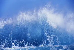 Blue Waves Crashing On The Shore With Blue Sky Background Blue Waves Crashing On The Shore With Blue Sky Background
