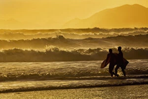 Images Dated 18th January 2014: Body Surfers Walk In The Water On The Coast Of Kodiak Island During Late Afternoon