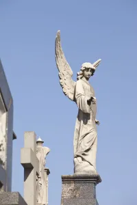 Buenos Aires, Argentina; Angel Statues And A Cross Made Of Stone On Top Of Tombs In The Recoleta Cemetery Buenos Aires, Argentina; Angel Statues And A Cross Made Of Stone On Top Of Tombs In The Recoleta Cemetery