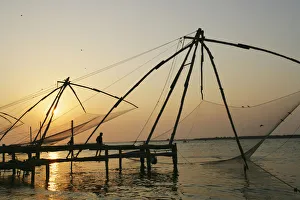 Chinese Fishing Nets Hanging In The Water At Sunset, Fort Kochi Chinese Fishing Nets Hanging In The Water At Sunset, Fort Kochi