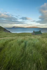 Dibidil Bothy at dusk with the Isle of Eigg in the background, Rum; Scotland, United Kingdom Dibidil Bothy at dusk with the Isle of Eigg in the background, Rum; Scotland, United Kingdom