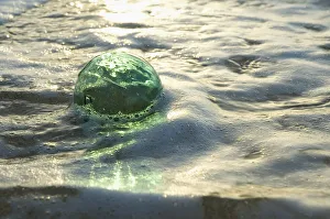 A Glass Fishing Ball Floats In Shallow Water For sale as Framed Prints,  Photos, Wall Art and Photo Gifts