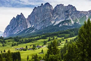 Grassy mountain side with jagged mountain tops in the background at the resort town of Cortina d' Grassy mountain side with jagged mountain tops in the background at the resort town of Cortina d'
