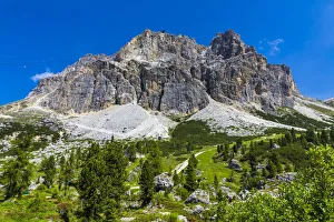 Grassy mountain side with the mountain tops of the Dolomites at the Falzarego Pass in the Province of Belluno, Italy Grassy mountain side with the mountain tops of the Dolomites at the Falzarego Pass in the Province of Belluno, Italy