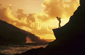 Hawaii, Golfer Standing On A Cliff And Swinging A Golf Club Hawaii, Golfer Standing On A Cliff And Swinging A Golf Club