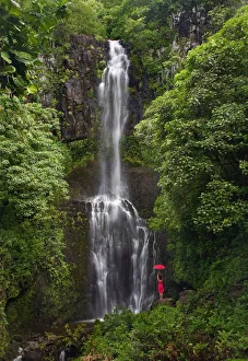 Hawaii, Maui, Kipahulu, Hana Coast, Woman Stands With Umbrella At Wailua Falls Surrounded By Foliage Hawaii, Maui, Kipahulu, Hana Coast, Woman Stands With Umbrella At Wailua Falls Surrounded By Foliage