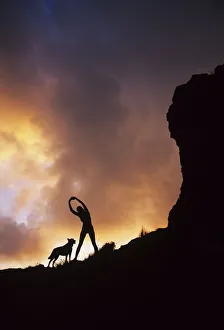 Hawaii, Silhouette Of A Woman Stretching On A Mountain Top At Sunset Hawaii, Silhouette Of A Woman Stretching On A Mountain Top At Sunset
