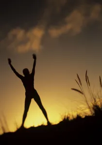 Hawaii, Silhouette Of A Woman Stretching On A Mountain Top At Sunset Hawaii, Silhouette Of A Woman Stretching On A Mountain Top At Sunset