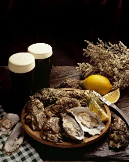 High Angle View Of A Platter Of Oysters With Glasses Of Beer On A Table High Angle View Of A Platter Of Oysters With Glasses Of Beer On A Table