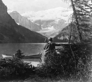 Historic image in black and white of a man at a lake in the Rocky Mountains, circa 1900; Alberta, Canada Historic image in black and white of a man at a lake in the Rocky Mountains, circa 1900; Alberta, Canada