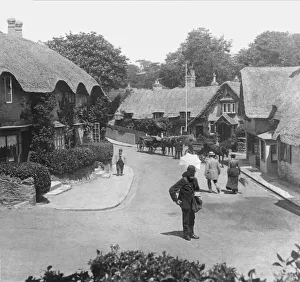 Historic image in black and white of thatched cottages on the Isle of Wight, with a postman Historic image in black and white of thatched cottages on the Isle of Wight, with a postman