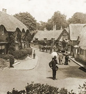 Historic image in sepia of thatched cottages in a village on the Isle of Wight, with a postman Historic image in sepia of thatched cottages in a village on the Isle of Wight, with a postman