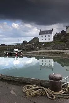 Houses Along The Water And A Boat On The Shore; St. Abbs Head, Scottish Borders, Scotland