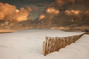 Illuminated Clouds Glowing Over A Snow Covered Field And Fence; South Shields, Tyne And Wear, England Illuminated Clouds Glowing Over A Snow Covered Field And Fence; South Shields, Tyne And Wear, England