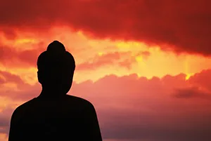 Indonesia, Java, Borobudur, Temple Relic, Buddhist Statue At Sunset, Silhouetted By Pink Sky Indonesia, Java, Borobudur, Temple Relic, Buddhist Statue At Sunset, Silhouetted By Pink Sky